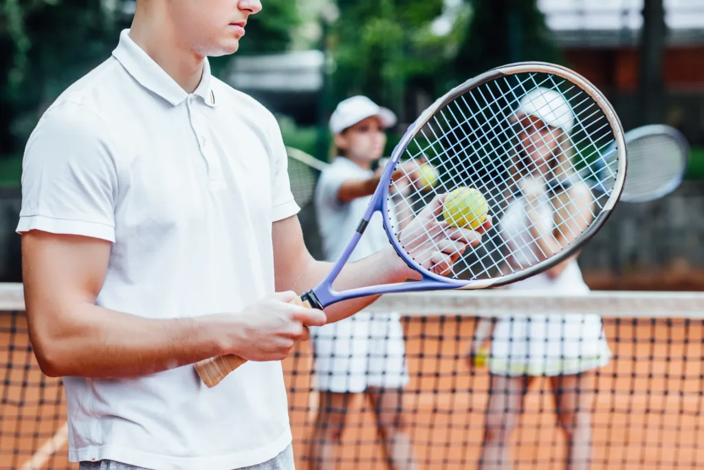 man swinging tennis racket with both hands make strong shot practice night before match